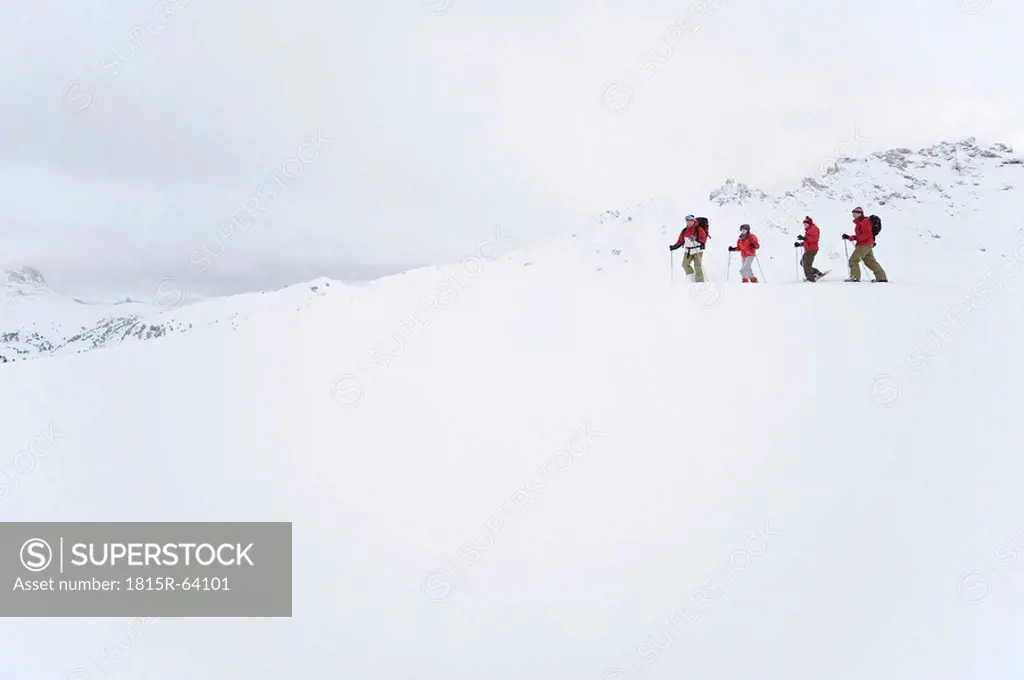 Italy, South Tyrol, Four people snowshoeing