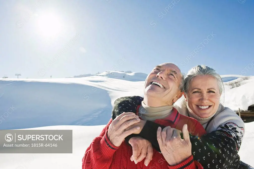 Italy, South Tyrol, Seiseralm, Senior couple embracing in winter scenery, portrait, close_up
