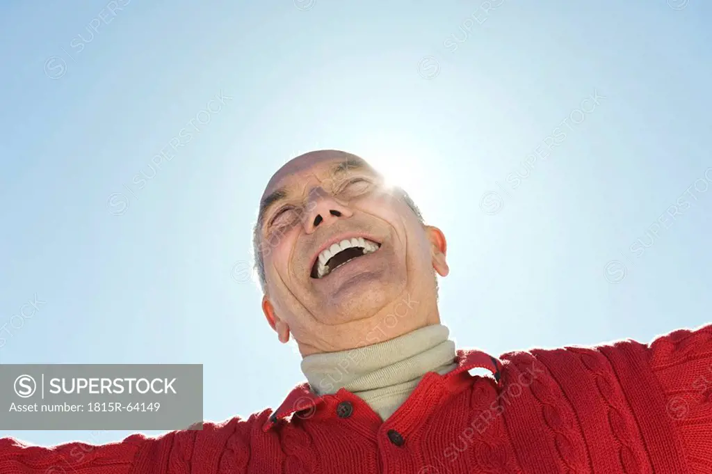 Italy, South Tyrol, Seiseralm, Senior man laughing, low angle view, portrait