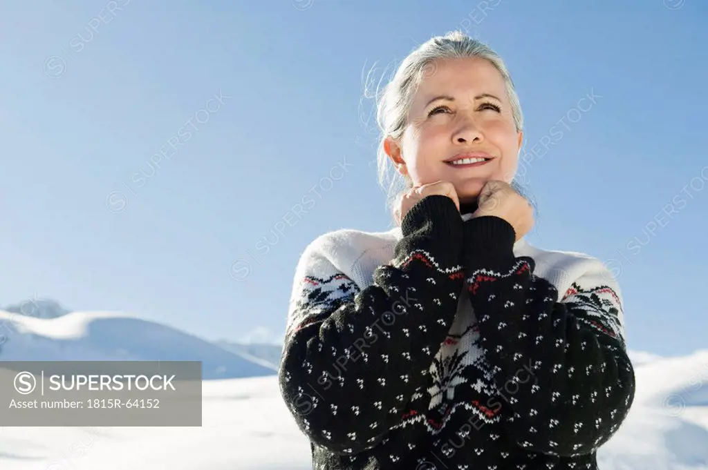 Italy, South Tyrol, Seiseralm, Senior woman, hands on chin, smiling, portrait