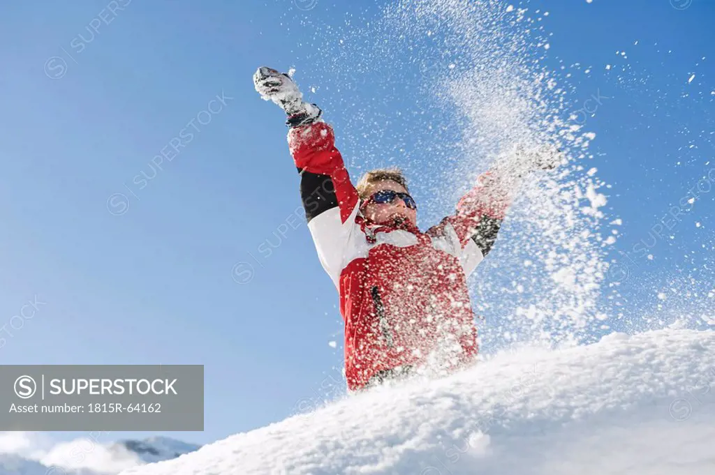 Italy, South Tyrol, Seiseralm, Boy 4_5 playing in snow, cheering, low angle view