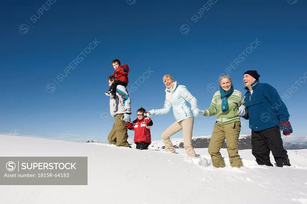 Italy, South Tyrol, Seiseralm, Family Walking in the Snow