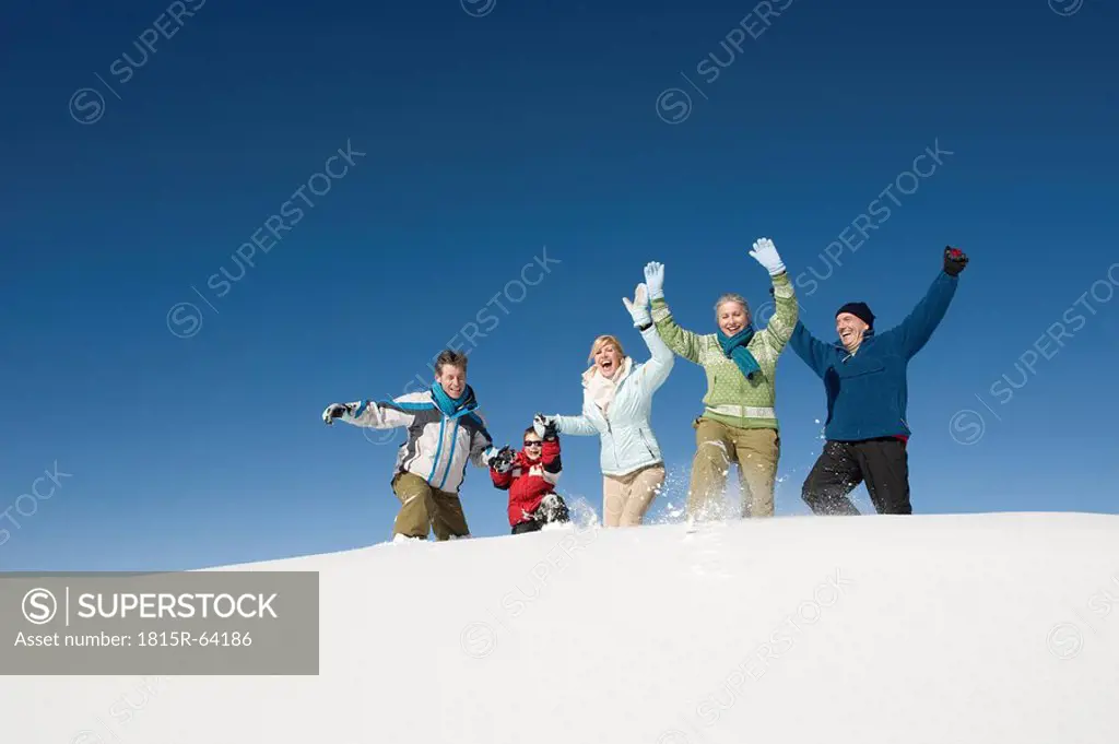Italy, South Tyrol, Seiseralm, Family walking in snow, cheering