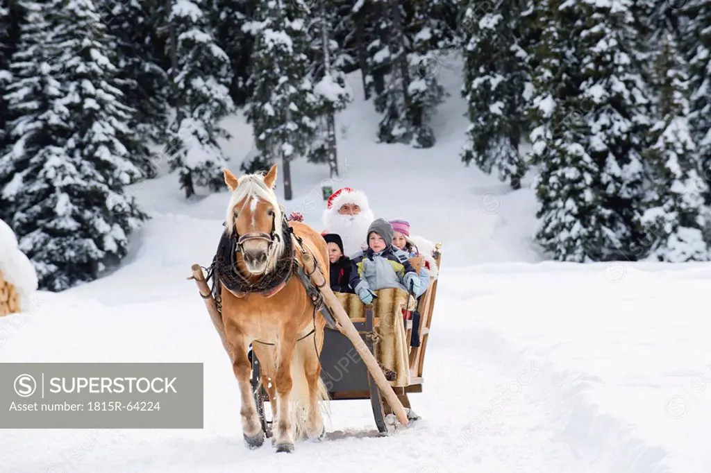 Italy, South Tyrol, Seiseralm, Santa Claus and children taking a sleigh ride
