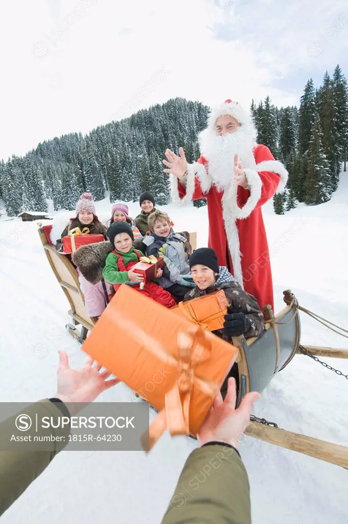 Italy, South Tyrol, Seiseralm, Santa Claus and children, children holding gift parcels