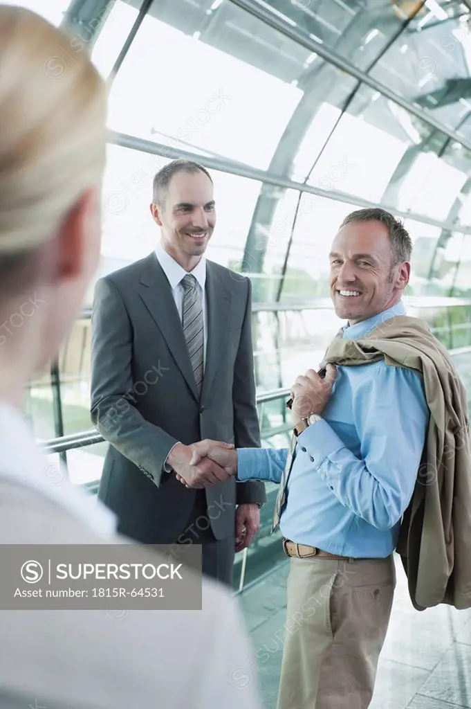 Germany, Leipzig_Halle, Airport, Business people shaking hands, smiling