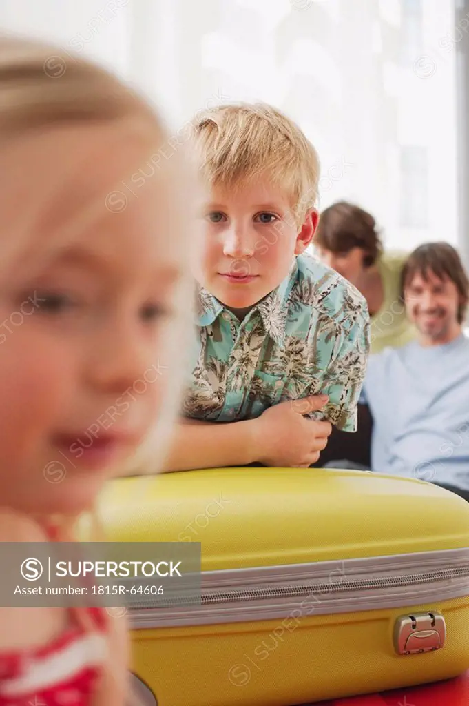 Germany, Leipzig, Family at home, boy 8_9 resting on suitcase, portrait