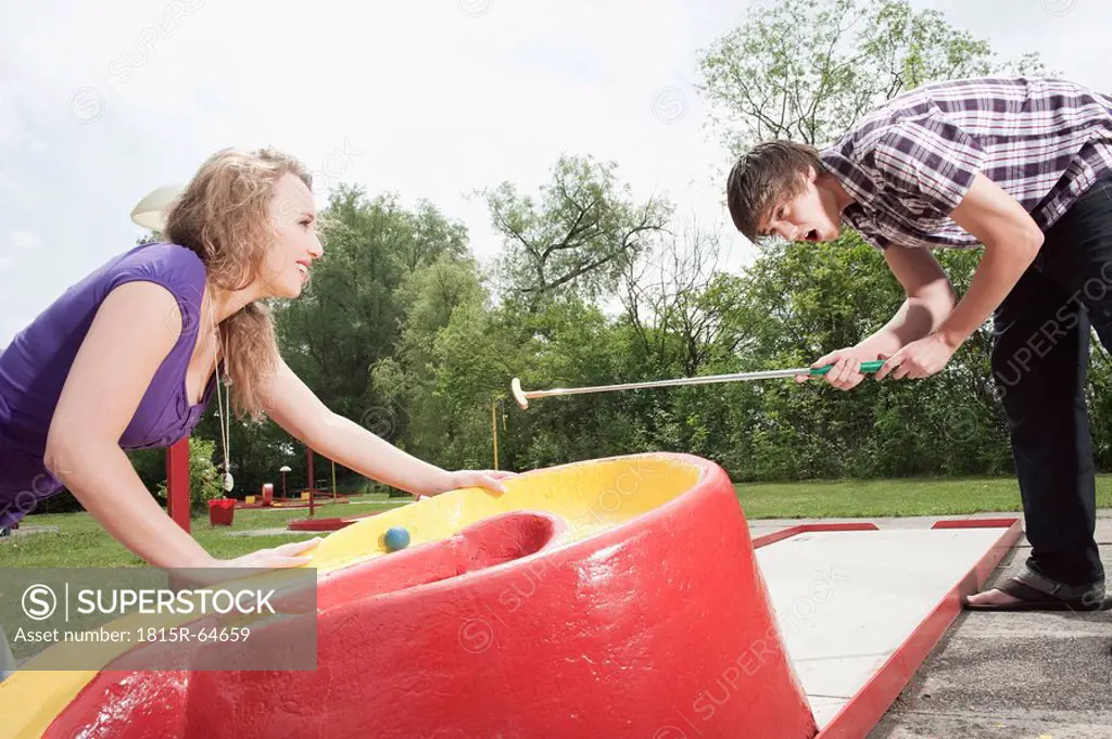 Germany, Bavaria, Ammersee, Young couple playing mini golf