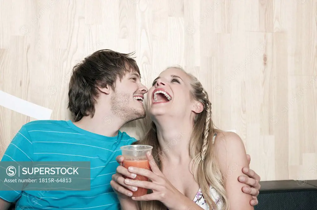 Germany, Cologne, Young couple in cafe, laughing, portrait