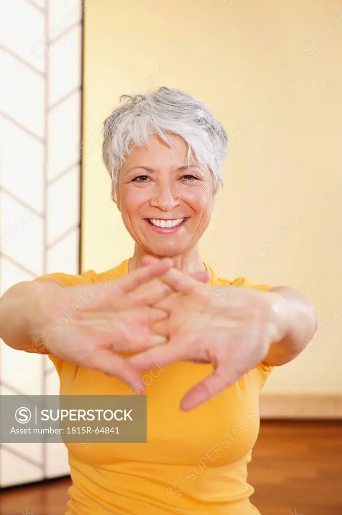 Senor woman stretching hands, smiling, portrait