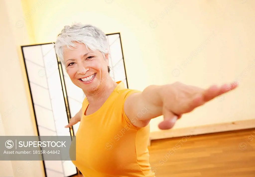 Senior woman with outstretched arms, smiling, portrait