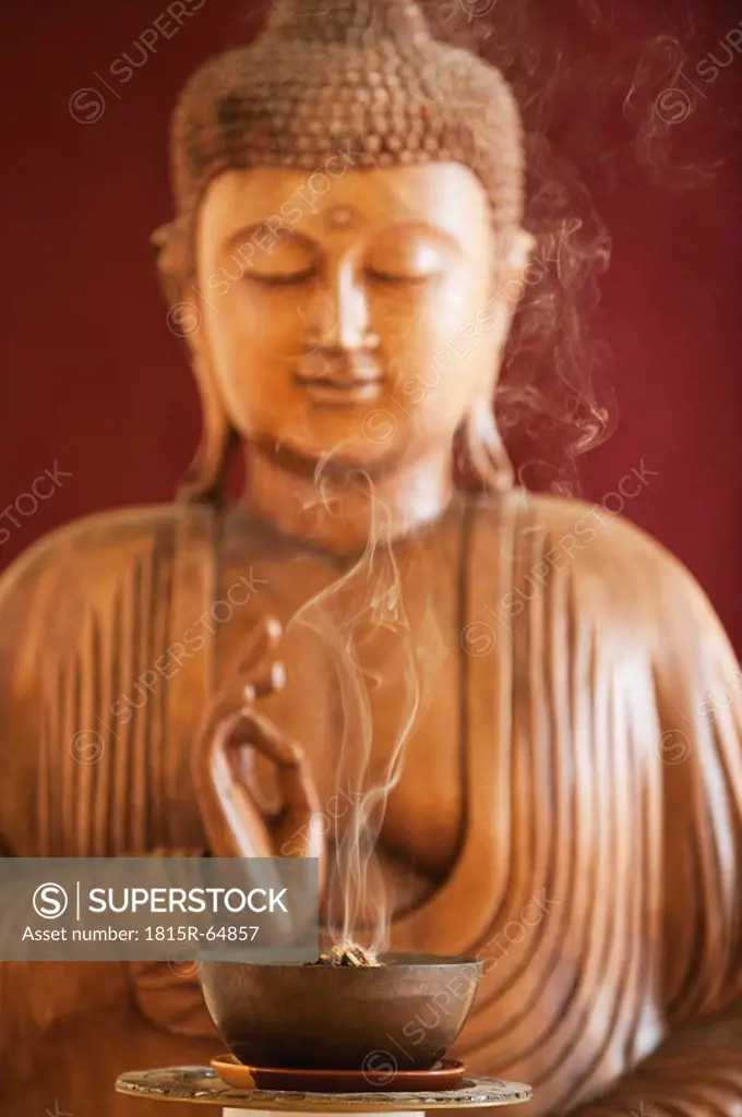 Buddha statue and a bowl with joss sticks