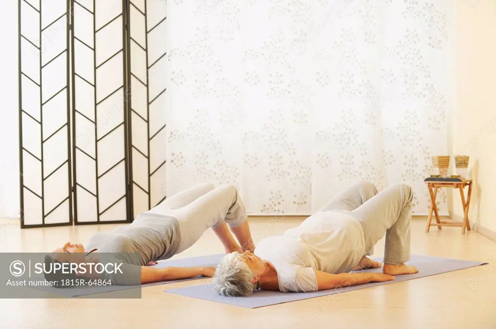 Two women arching back on gym mat