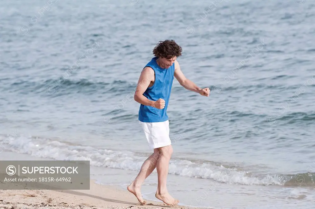 Spain, Mallorca, Man jogging on beach