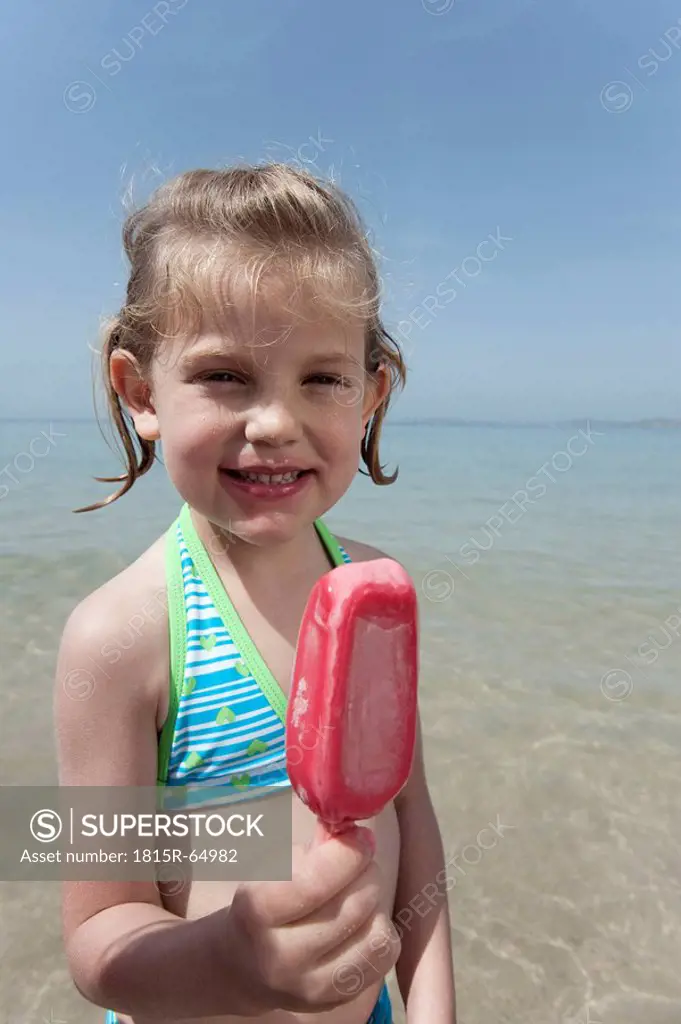 Spain, Mallorca, Girl 4_5 eating icecream on beach, portrait