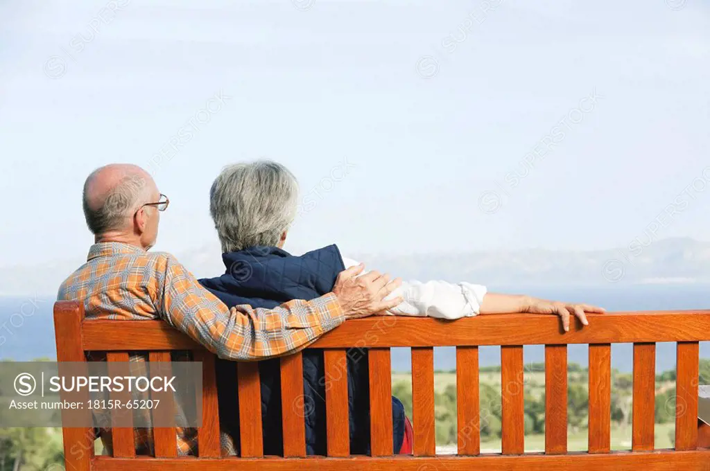 Spain, Mallorca, Senior couple sitting on bench, rear view