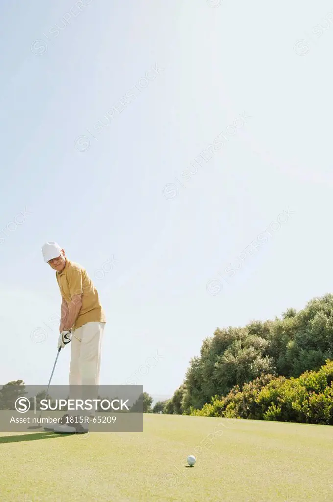 Spain, Mallorca, Senior man playing golf, side view