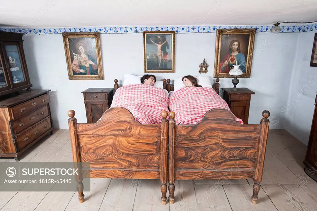 Germany, Bavaria, Young couple lying in bedroom