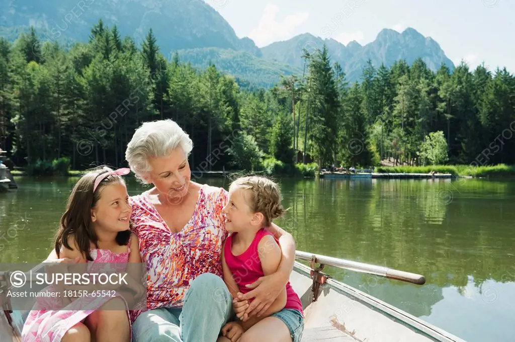 Italy, South Tyrol, Grandmother and grandchildren 6_7 8_9 sitting in rowing boat, portrait