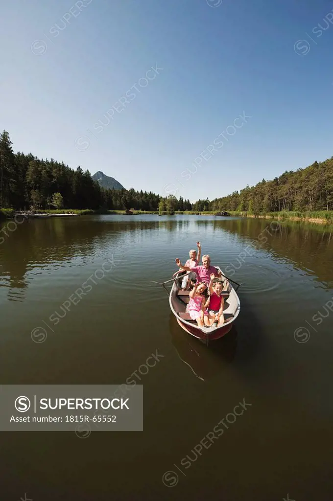 Italy, South Tyrol, Grandparents and children 6_7 8_9 in rowing boat on lake, portrait