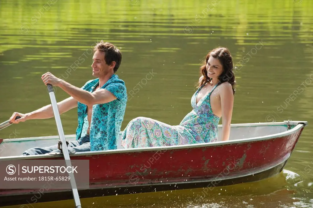 Italy, South Tyrol, Young Couple on a Lake rowing a Boat