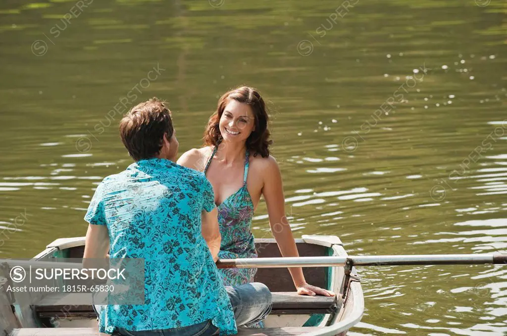 Italy, South Tyrol, Young Couple on a lake rowing