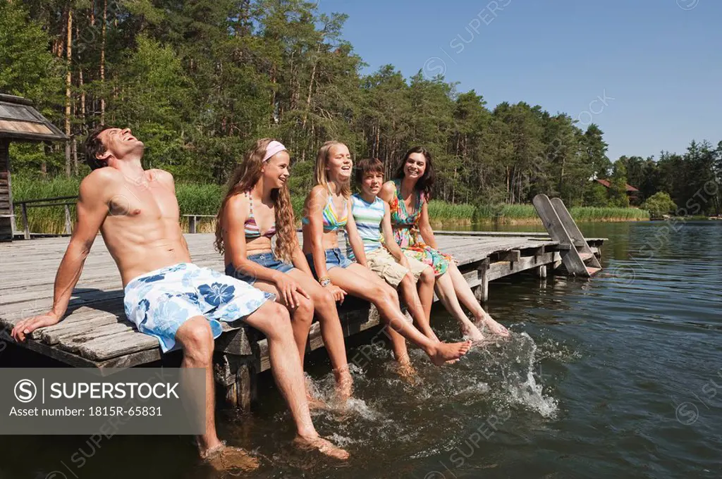 Italy, South Tyrol, Family sitting on jetty, relaxing