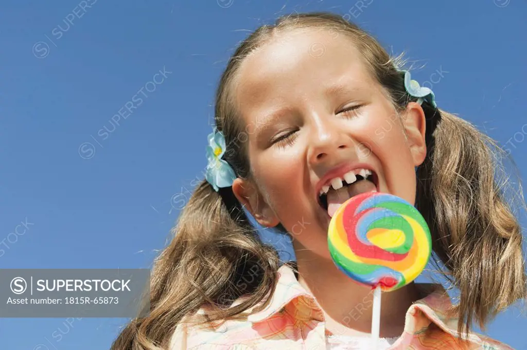 Italy, South Tyrol, Girl 6_7 licking lollypop, portrait, close_up