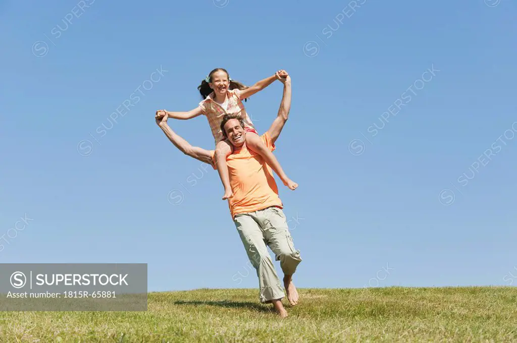 Italy, South Tyrol, Father carrying daughter 6_7 on his shoulder, laughing, portrait