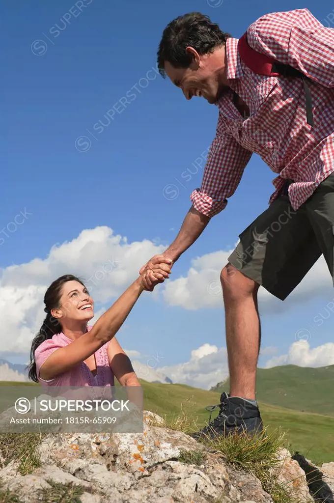 Italy, South Tyrol, Climber helping woman