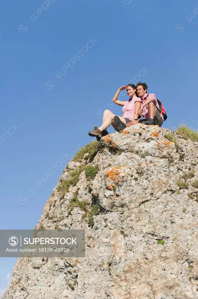 Italy, South Tyrol, Hiker couple sitting on rock