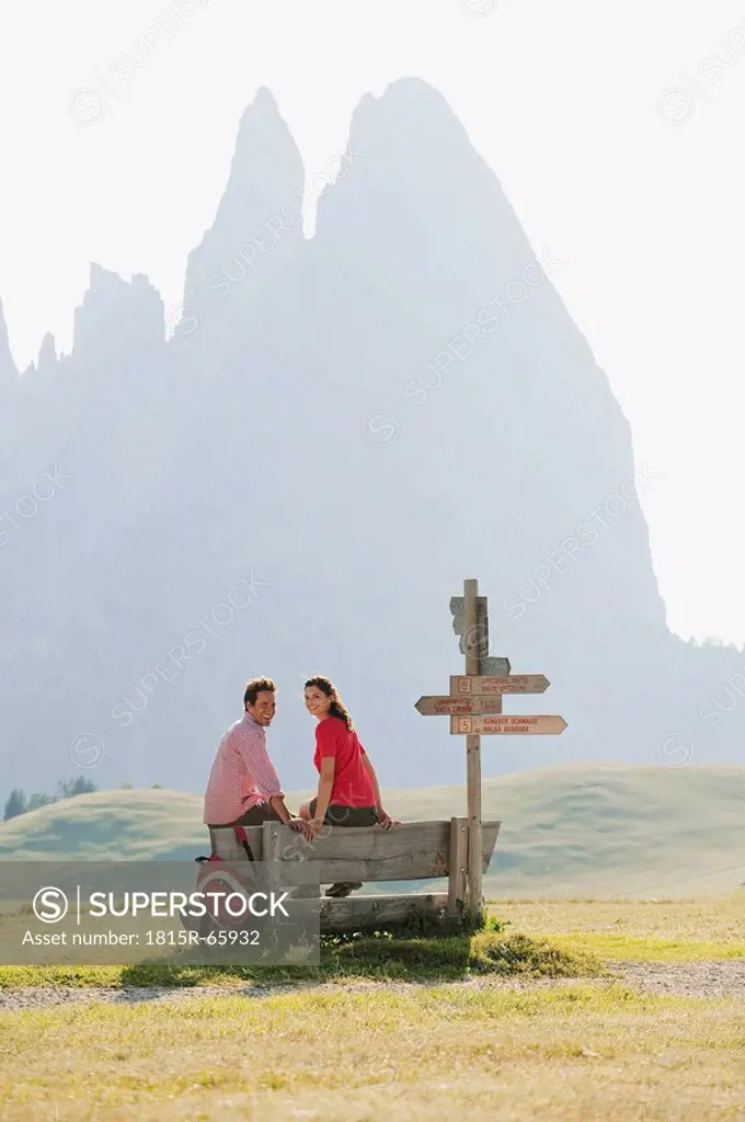 Italy, South Tyrol, Seiseralm, Couple sitting on bench