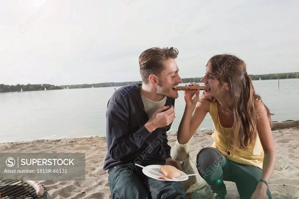 Germany, Berlin, Lake Wannsee, Young couple having a barbecue