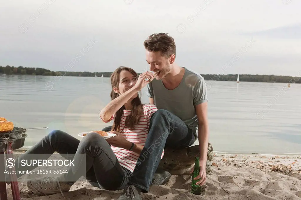 Germany, Berlin, Lake Wannsee, Young couple having a barbecue