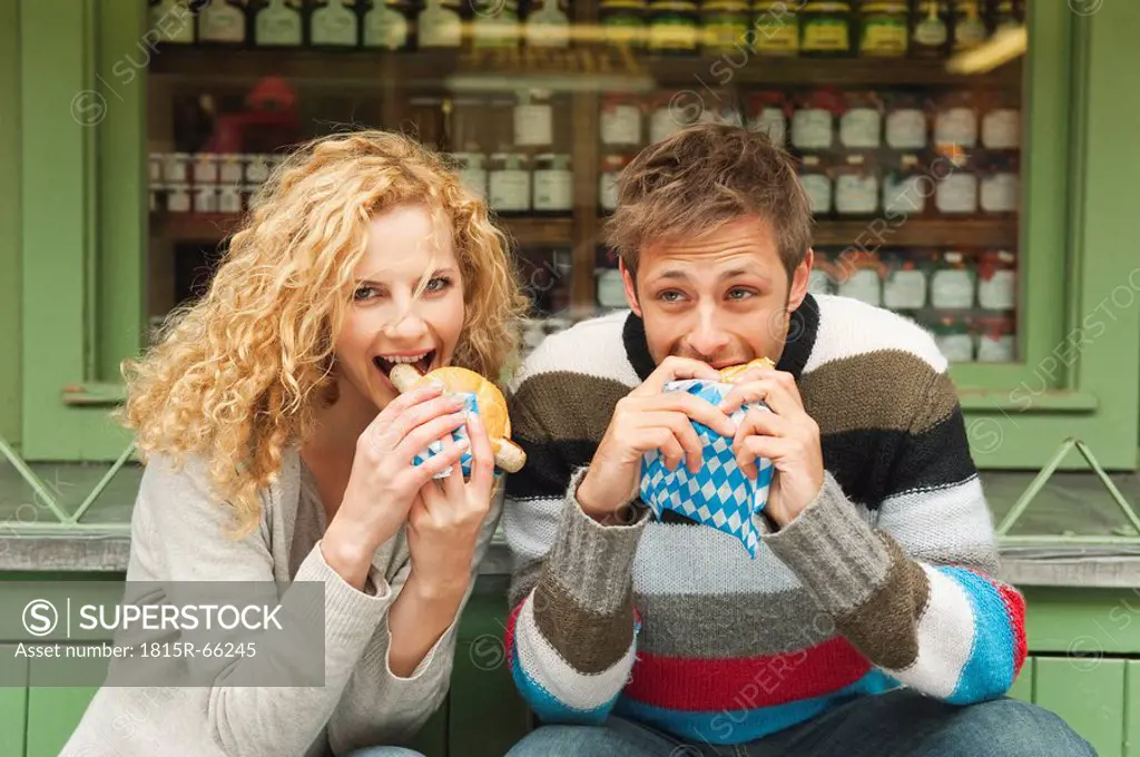 Germany, Bavaria, Munich, Young couple at Viktualienmarkt having snack, portrait