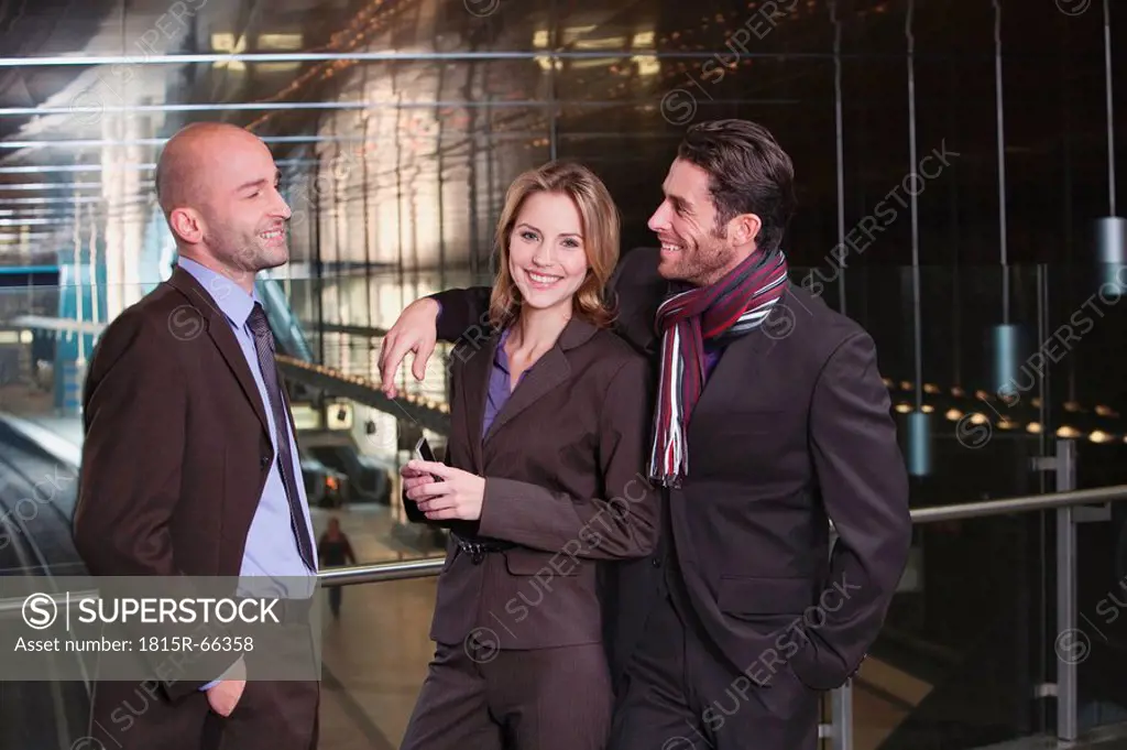Germany, Bavaria, Munich, Three business people at subway station, smiling, portrait