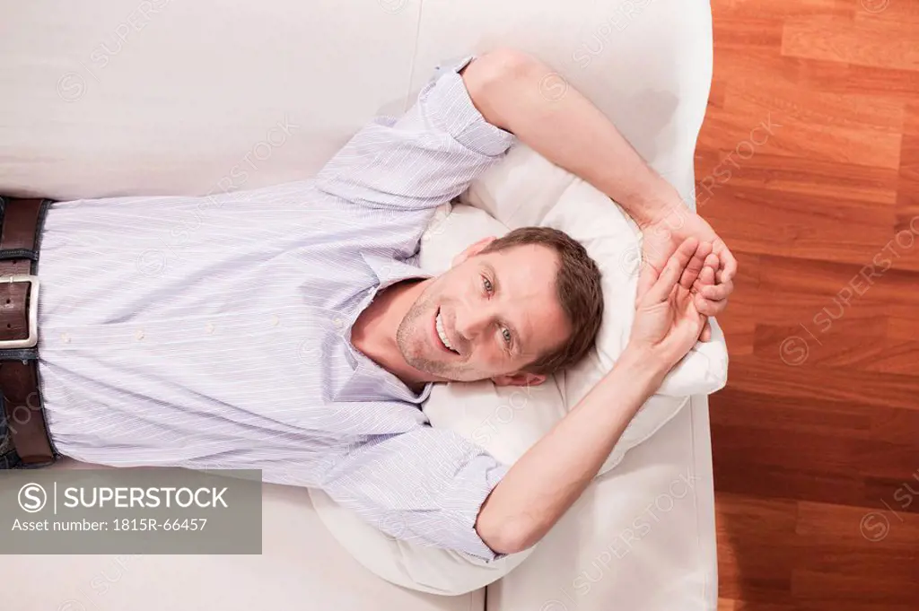 Germany, Cologne, Man relaxing on sofa, elevated view