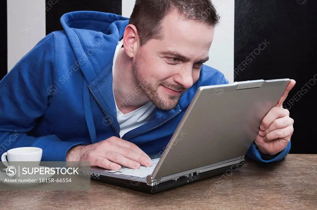 Man staring at laptop, smiling