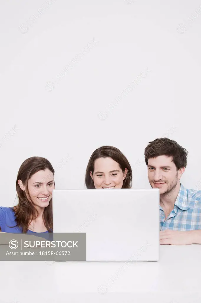 Man and women using laptop, smiling