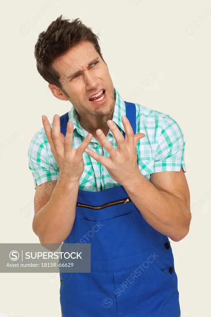 Man in overall showing frustrated expression