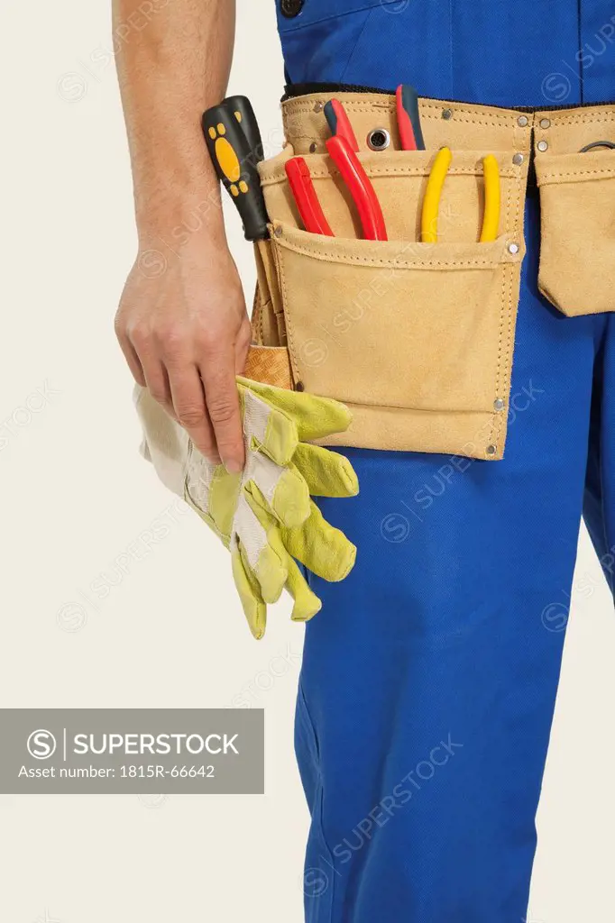 Man wearing tool belt and holding hammer, mid section, close_up