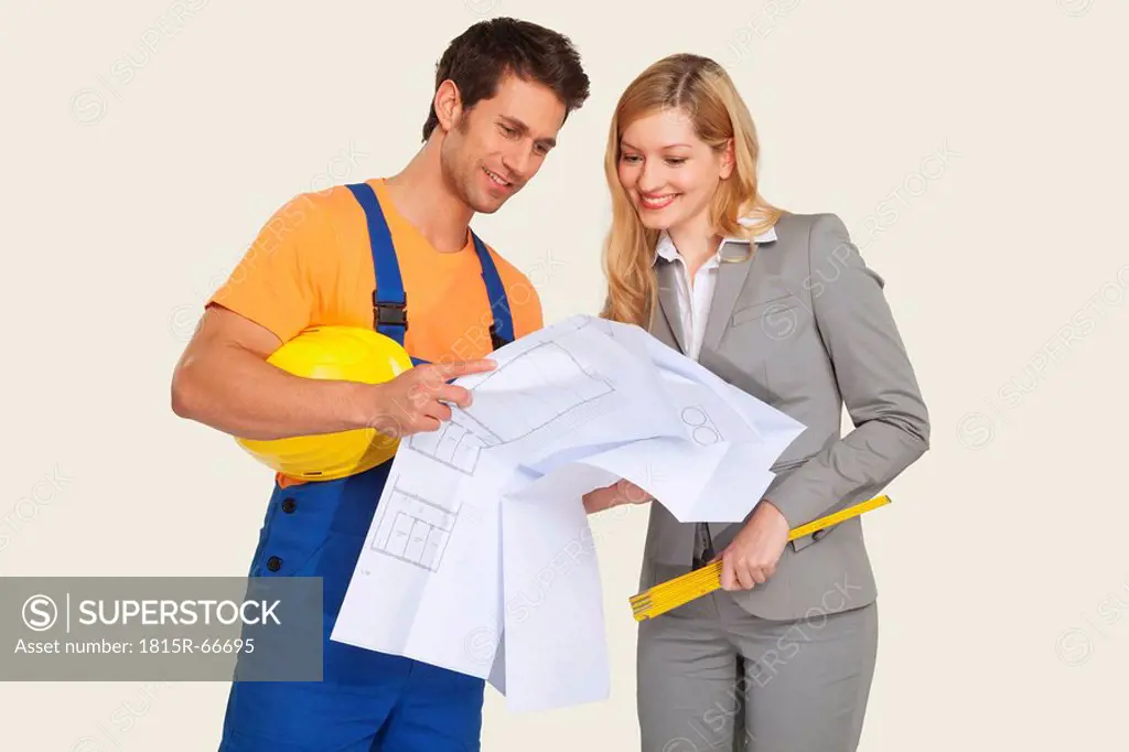 Construction worker and architect looking at blueprint