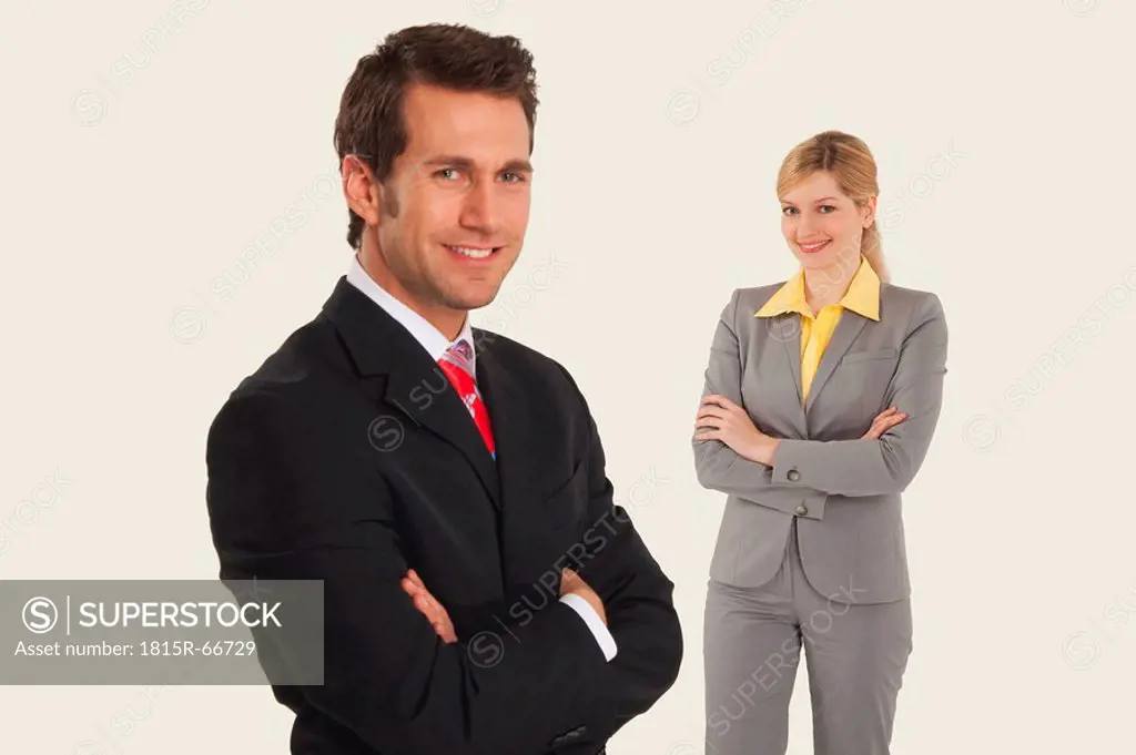 Businessmen smiling, women in behind, arms crossed.