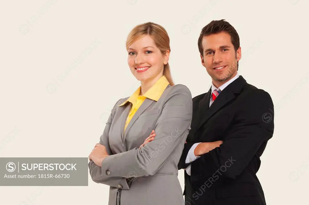 Businesswomen and men smiling, arms crossed.