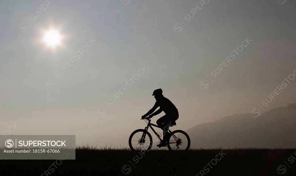 Man riding a mountain bike, twilight, silhouette