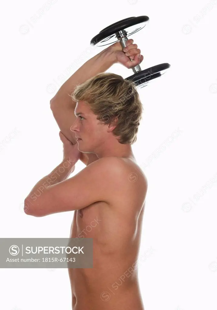 Young man lifting a dumbbell, side view, portrait
