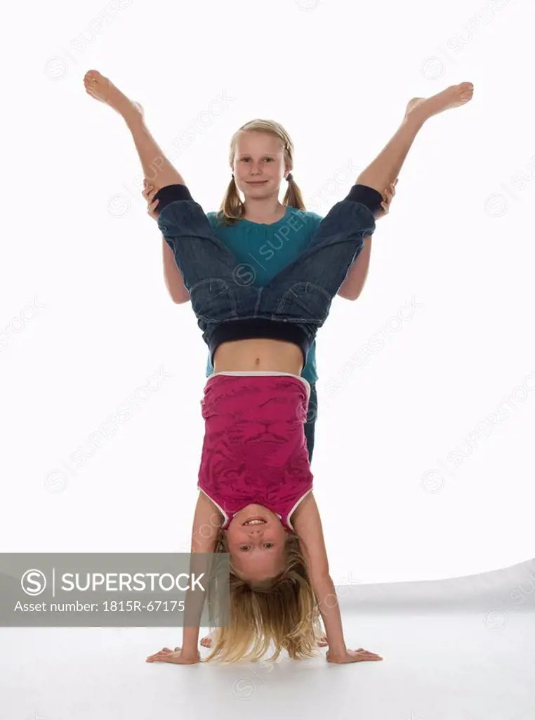 Two girls 10_11 one of them doing handstand, portrait