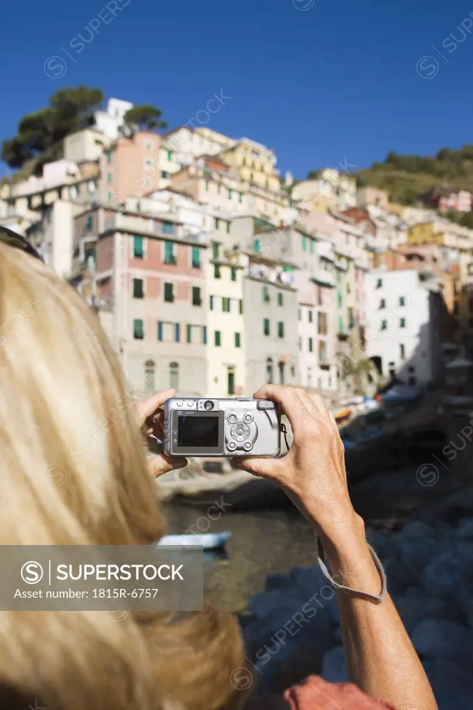 Italy, Liguria, Riomaggiore, Woman photographing houses