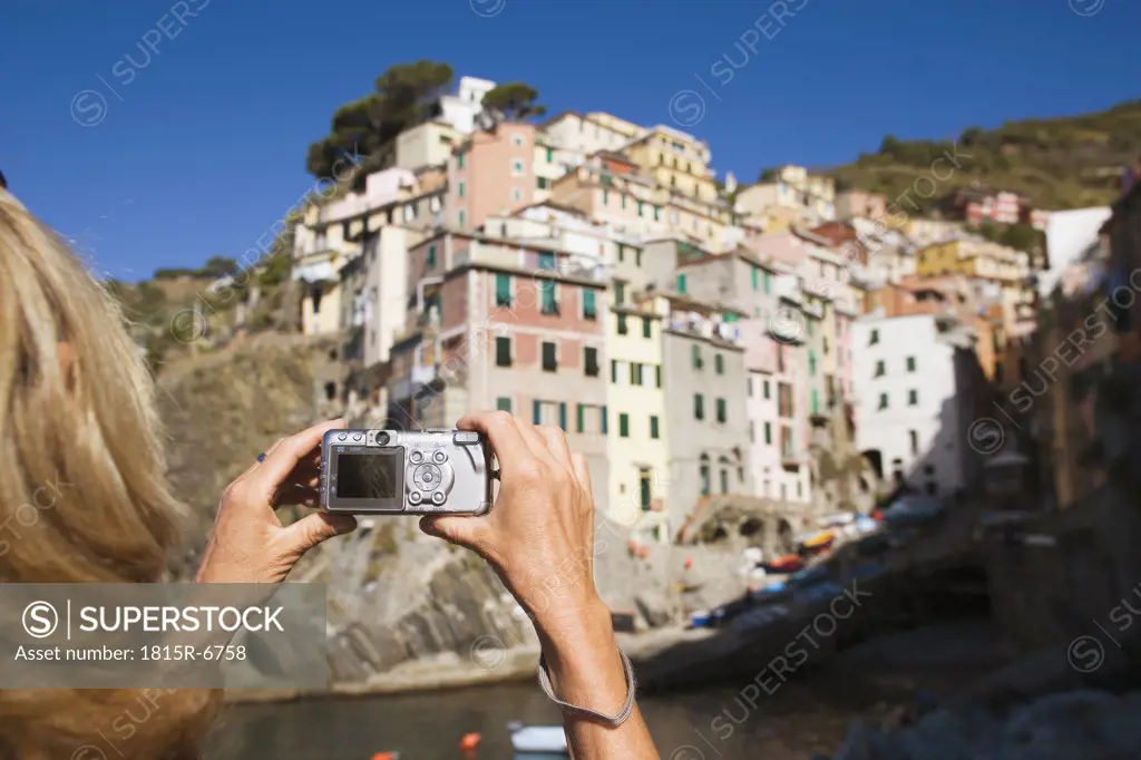 Italy, Liguria, Riomaggiore, Woman photographing houses