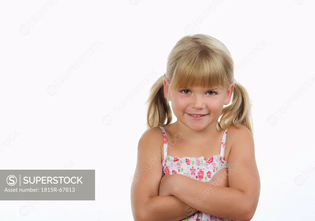 Girl 4_5 with arms crossed against white background, smiling, portrait